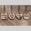 Laser engraved wooden pet tags in the shape of a square, hexagon, circle, and a heart